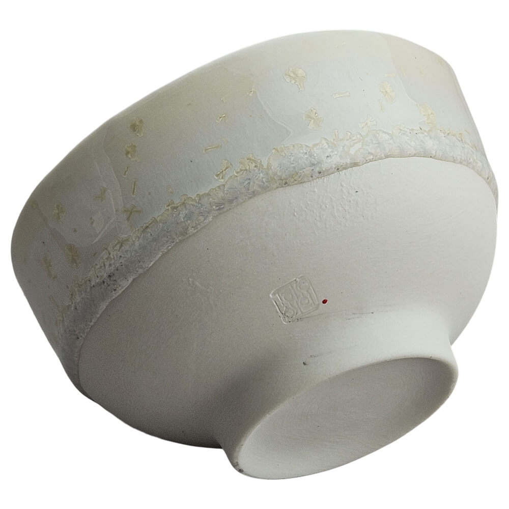 Unterseite der hellen Porzellan Teeschale von Atelier TōKo mit Standfuß und Signatur#teeschale_kristallglasur-2
