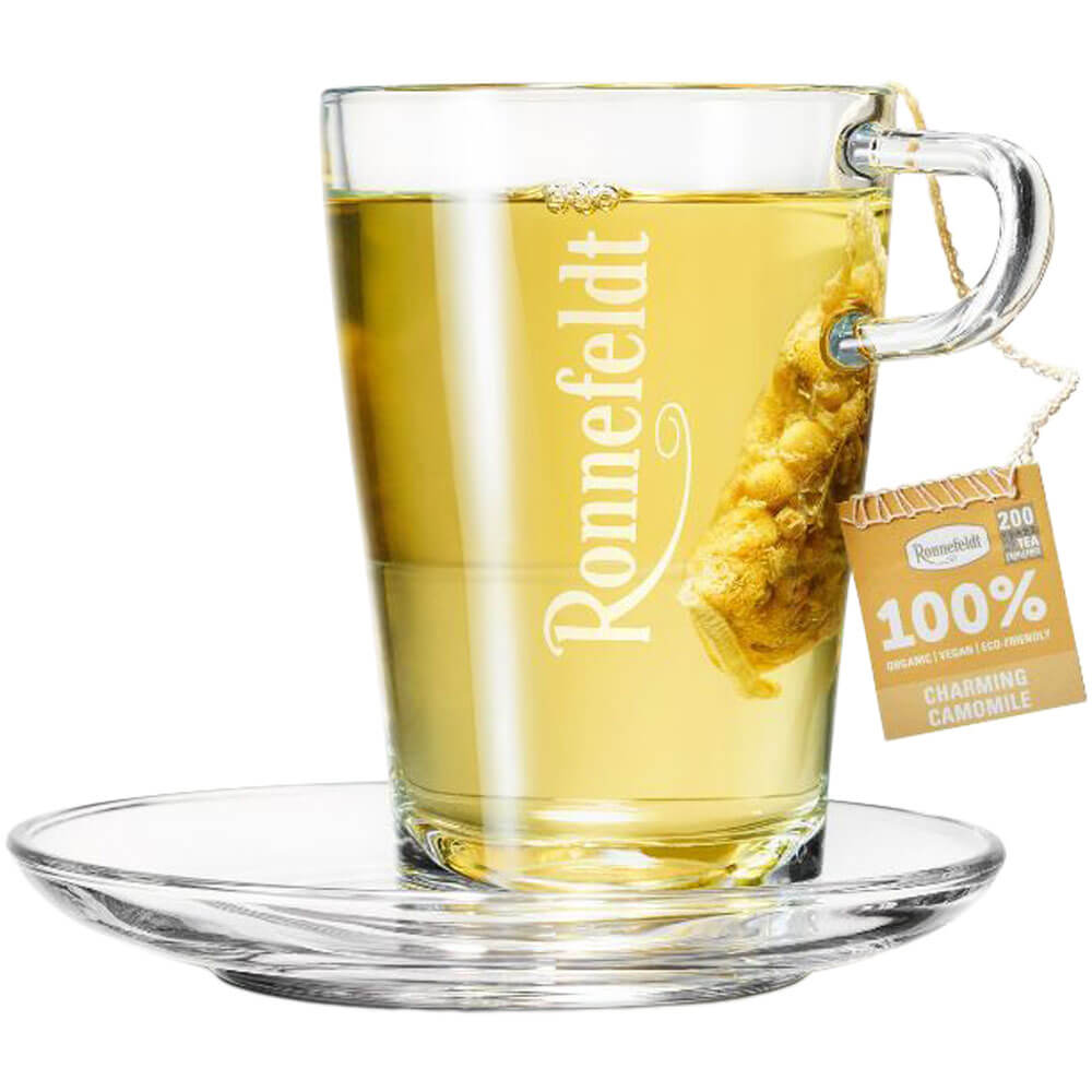 Ronnefeldt Premium Teebeutel Charming Camomile in Glastasse mit hellgelbem Kamillentee und Glasuntertasse