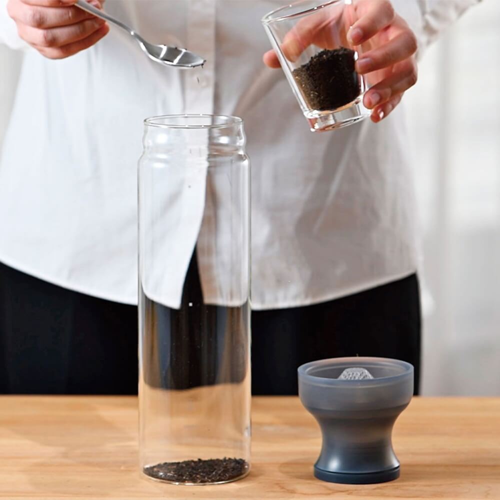 Zubereitung von Cold Brew Tee in der Hario Teeflasche mit Filter, loser Tee wird in die Glasflasche gegeben#teeflasche_gelb