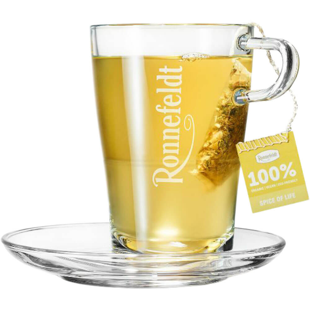 Ronnefeldt Premium Teebeutel Spice of Life in Glastasse mit hellgelbem Kräutertee und Glasuntertasse