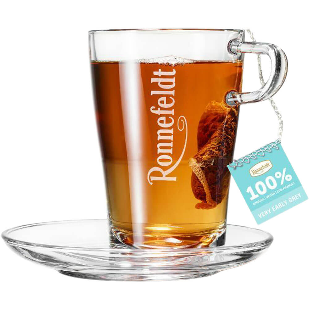 Ronnefeldt Premium Teebeutel Very Early Grey in Glastasse mit bernsteinfarbenem Schwarztee und Glasuntertasse
